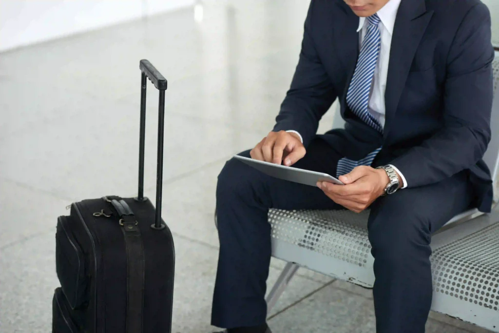 Pictured is a man with a suitcase waiting for a plane